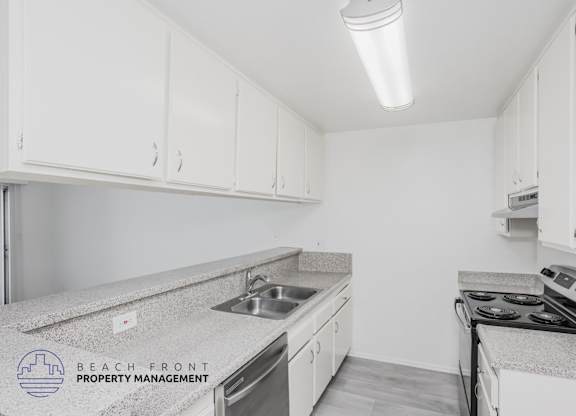 A kitchen with white cabinets and a granite countertop.