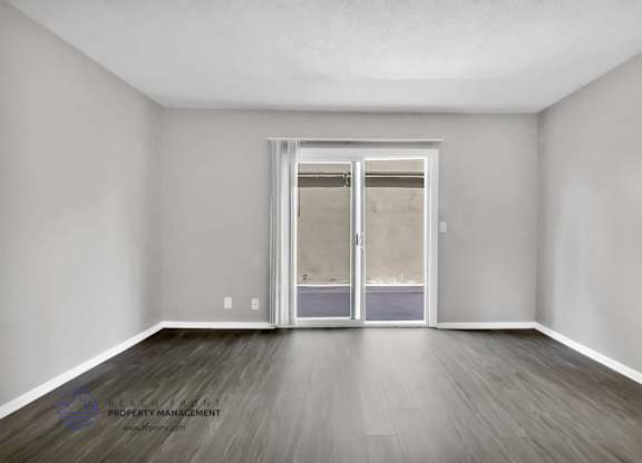 A room with a sliding door and wooden flooring.
