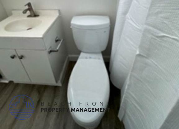 A white toilet sits next to a sink in a small bathroom.