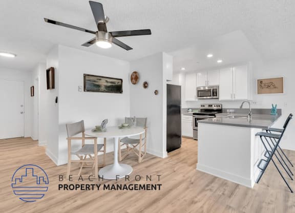 a living room and kitchen with a table and chairs and a ceiling fan