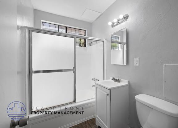 a bathroom with a shower and a toilet and a sink