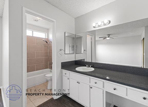 a bathroom with white cabinets and a sink and a mirror