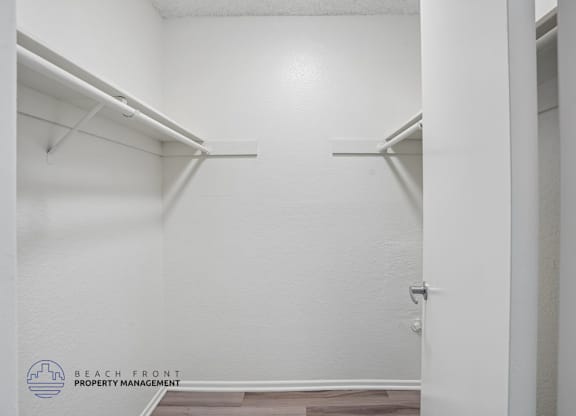 A white hallway with a door on the right and a wall on the left.