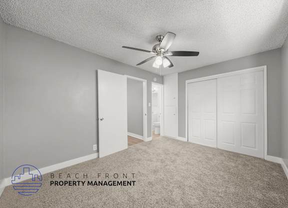 A room with a ceiling fan and a carpeted floor.