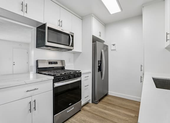 A kitchen with white cabinets and stainless steel appliances.