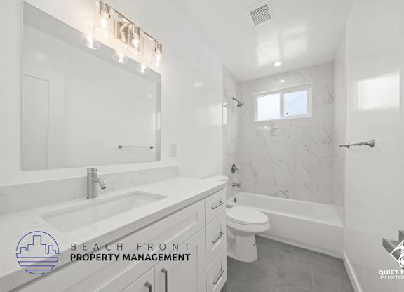 a white bathroom with a white sink and a toilet and a bath tub