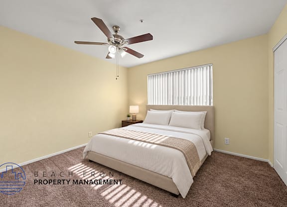 A bedroom with a bed, carpet, and a ceiling fan.