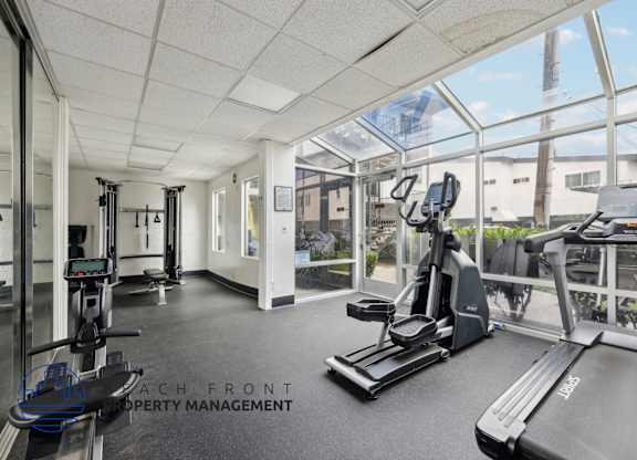 A gym with treadmills, weights, and exercise equipment.