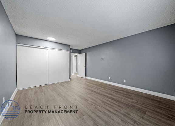 A room with wooden flooring and a sliding door.