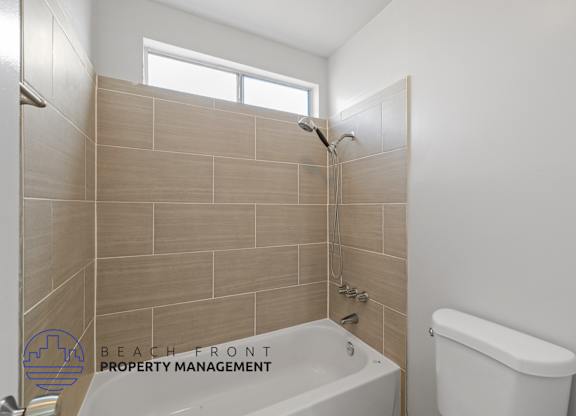 a bathroom with a tub and a toilet and a window