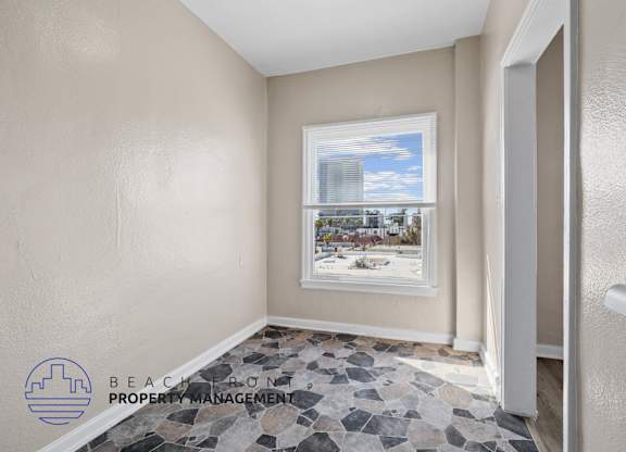 A room with a view of a cityscape through a window.