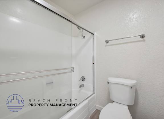 A white toilet in a bathroom with a glass shower door.