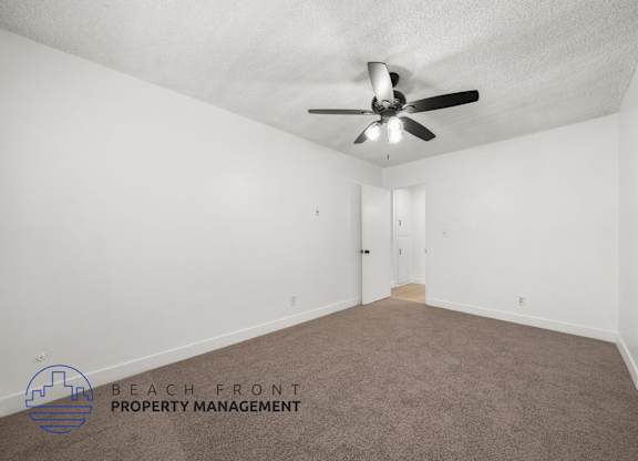 A room with a ceiling fan and a carpeted floor.