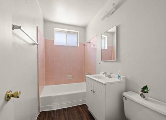 A white bathroom with a pink wall.