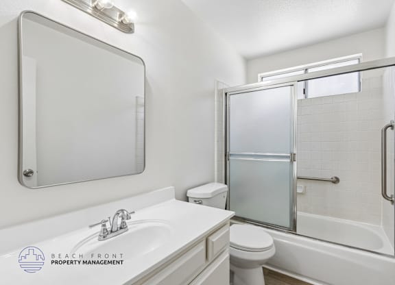 A white bathroom with a sink, toilet, and bathtub.