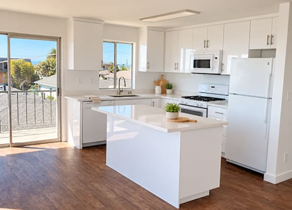 A white kitchen with a large island in the middle.