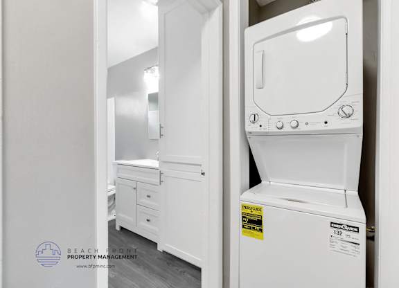 A white dishwasher is in a kitchen with a sticker on it.