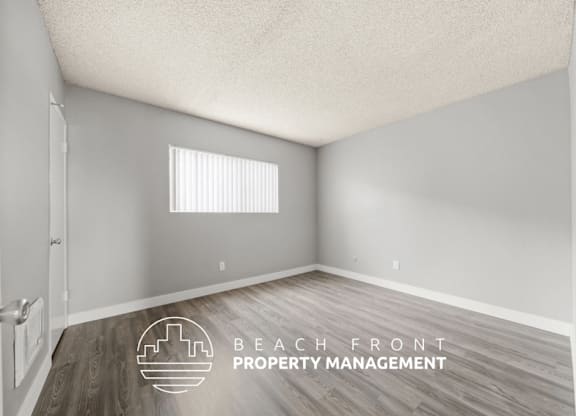 A room with a door, window, and a logo for Beach Front Property Management.