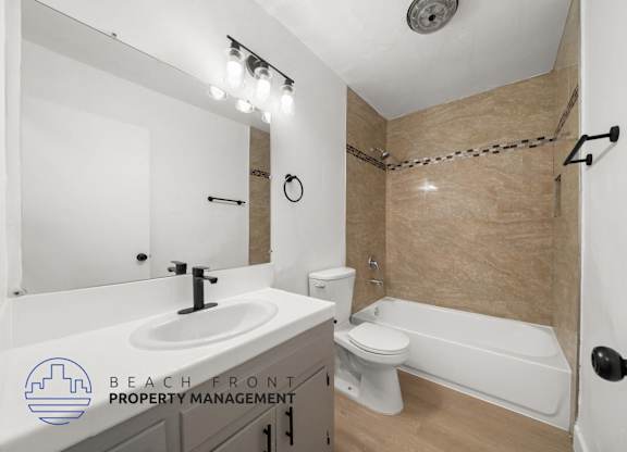 A bathroom with a sink, toilet, and bathtub.