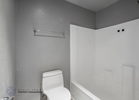 A white toilet is next to a white bathtub in a bathroom.