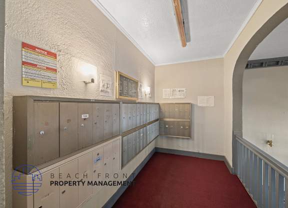 A long hallway with a red carpet and a sign that says Beach Front Property Management.