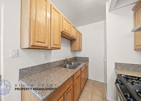 A kitchen with wooden cabinets and granite countertops.
