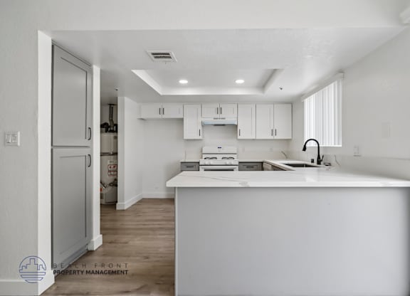 A white kitchen with a large island in the middle.