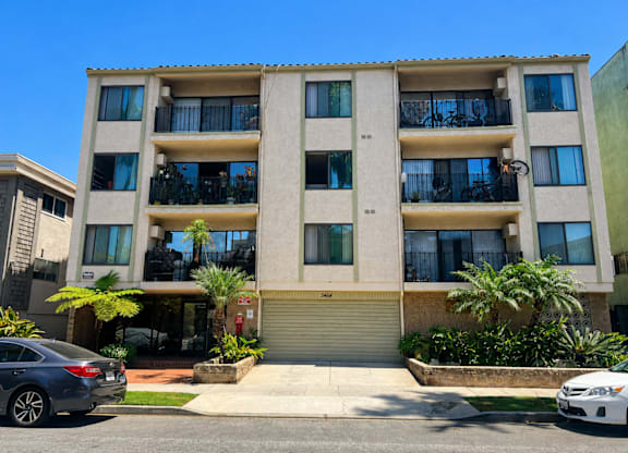 A modern apartment building with a car parked in front.