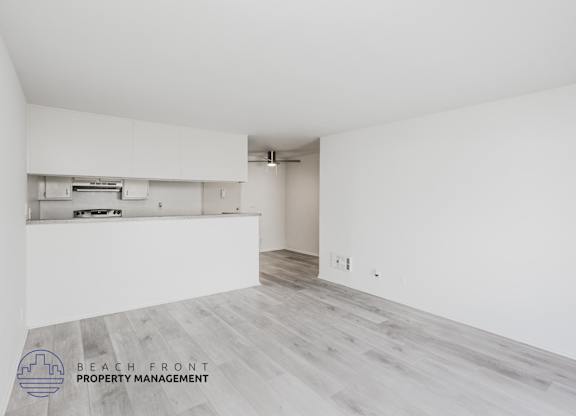 A spacious room with a logo for Beach Front Property Management in the bottom left corner.