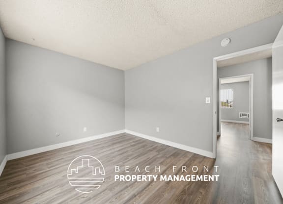 A room with a logo of Beach Front Property Management on the floor.
