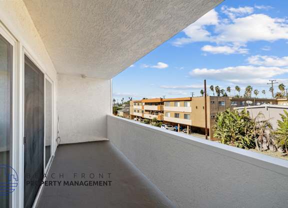 A balcony with a view of a building and trees.
