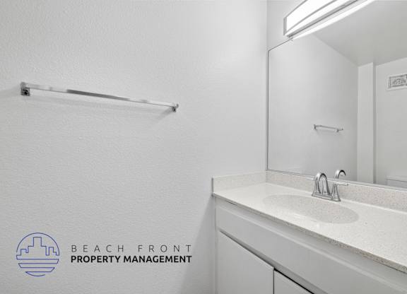 A bathroom with a white sink and mirror.