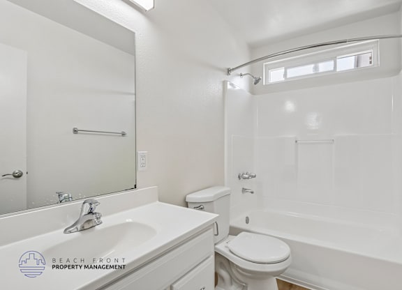 A white bathroom with a toilet, sink, and bathtub.