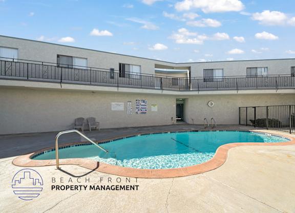 A pool with a slide and a sign that says Beach Front Property Management.