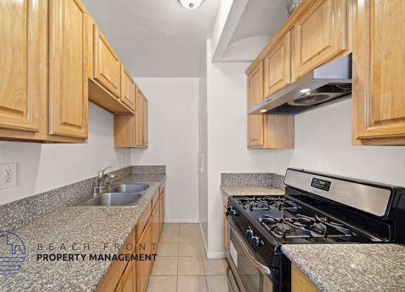 A kitchen with wooden cabinets and a granite countertop.
