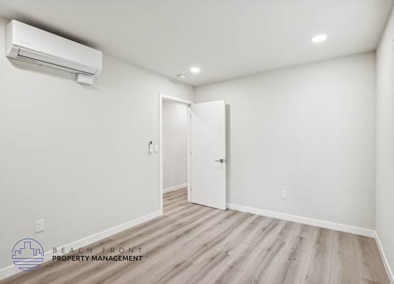A room with a white wall and a wooden floor.