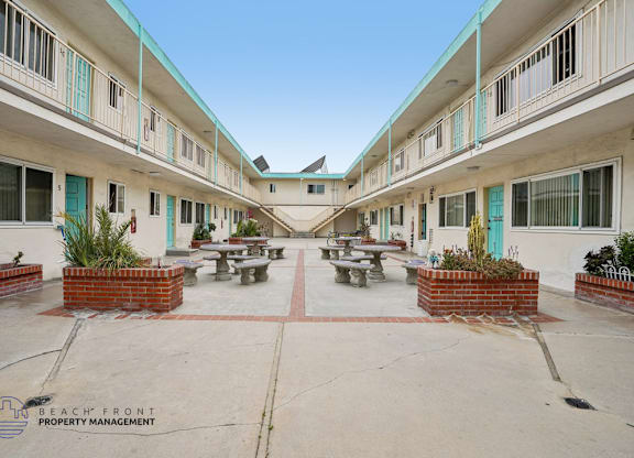 A courtyard with tables and chairs surrounded by buildings.