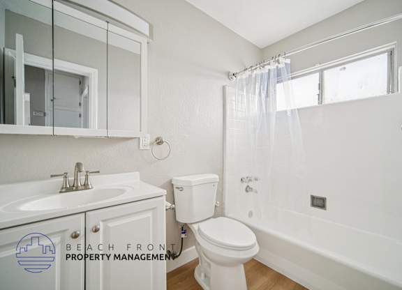 A white bathroom with a toilet, sink, and bathtub.