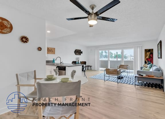 a living room with a ceiling fan and a table and chairs