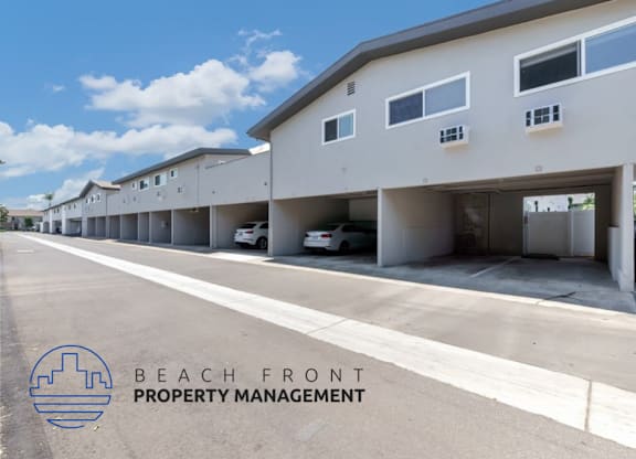 a beach front property management building with cars parked outside