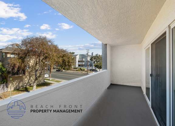 A balcony with a view of the street and houses.