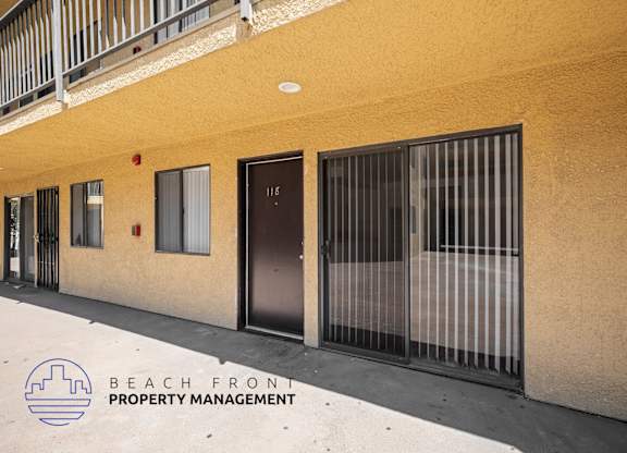 A building with a balcony and a sign that says Beach Front Property Management.