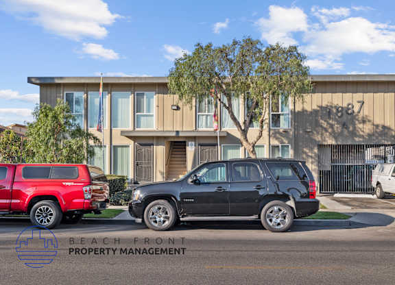 A black SUV is parked in front of a building with the number 1987 on it.