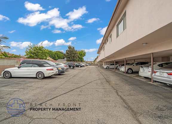 A parking lot with cars and a building in the background.