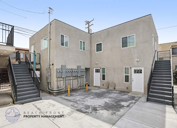 A concrete building with a staircase leading to the entrance.