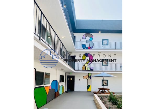 the front entrance of a building with a patio and surfboards