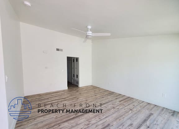 an empty room with white walls and a ceiling fan