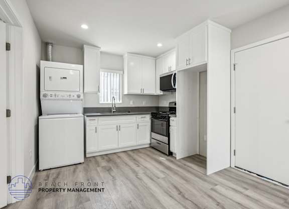 A kitchen with white appliances and cabinets.