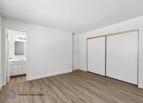 A room with a white door, a white cabinet, and a white wall.