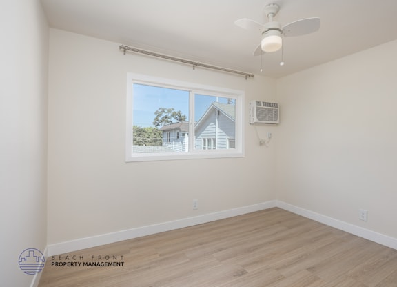 A room with a window showing a house outside.
